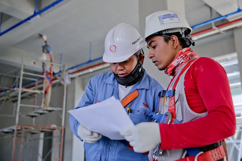 Construction professionals coordinating plans on site